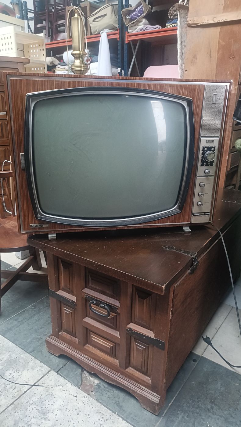 Televisión antigua con diseño retro y mando manual