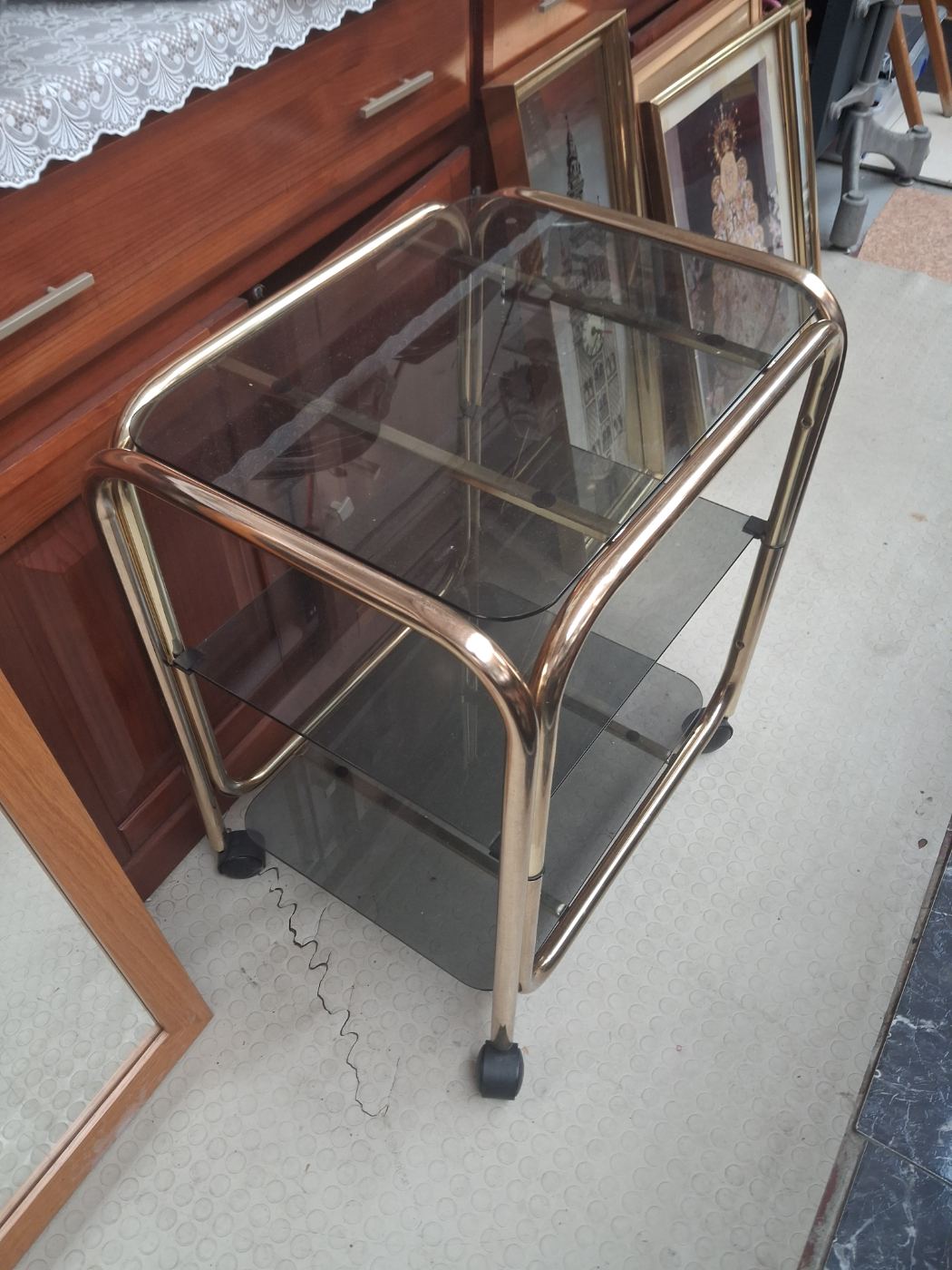 Carrito con estantes de cristal y estructura metálica dorada