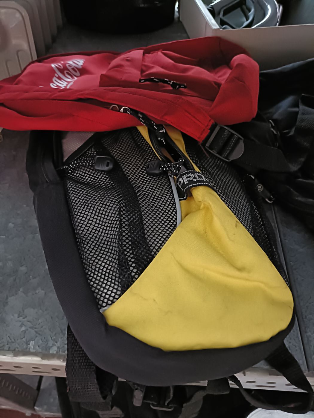Mochila deportiva amarilla y negra con mochila roja encima