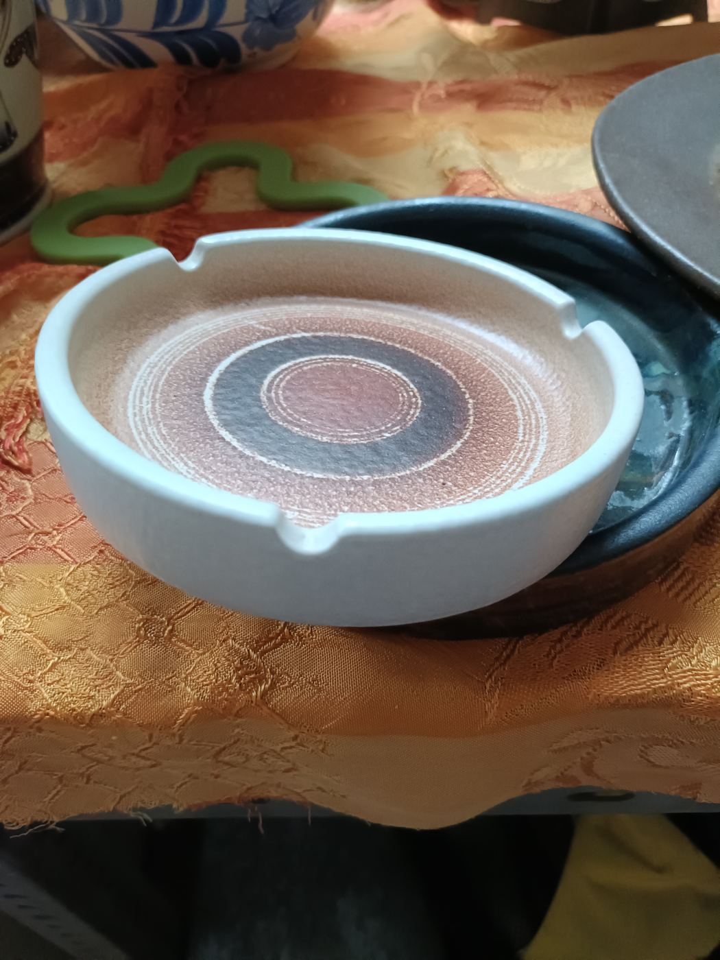 Cenicero redondo con diseño circular en tonos tierra