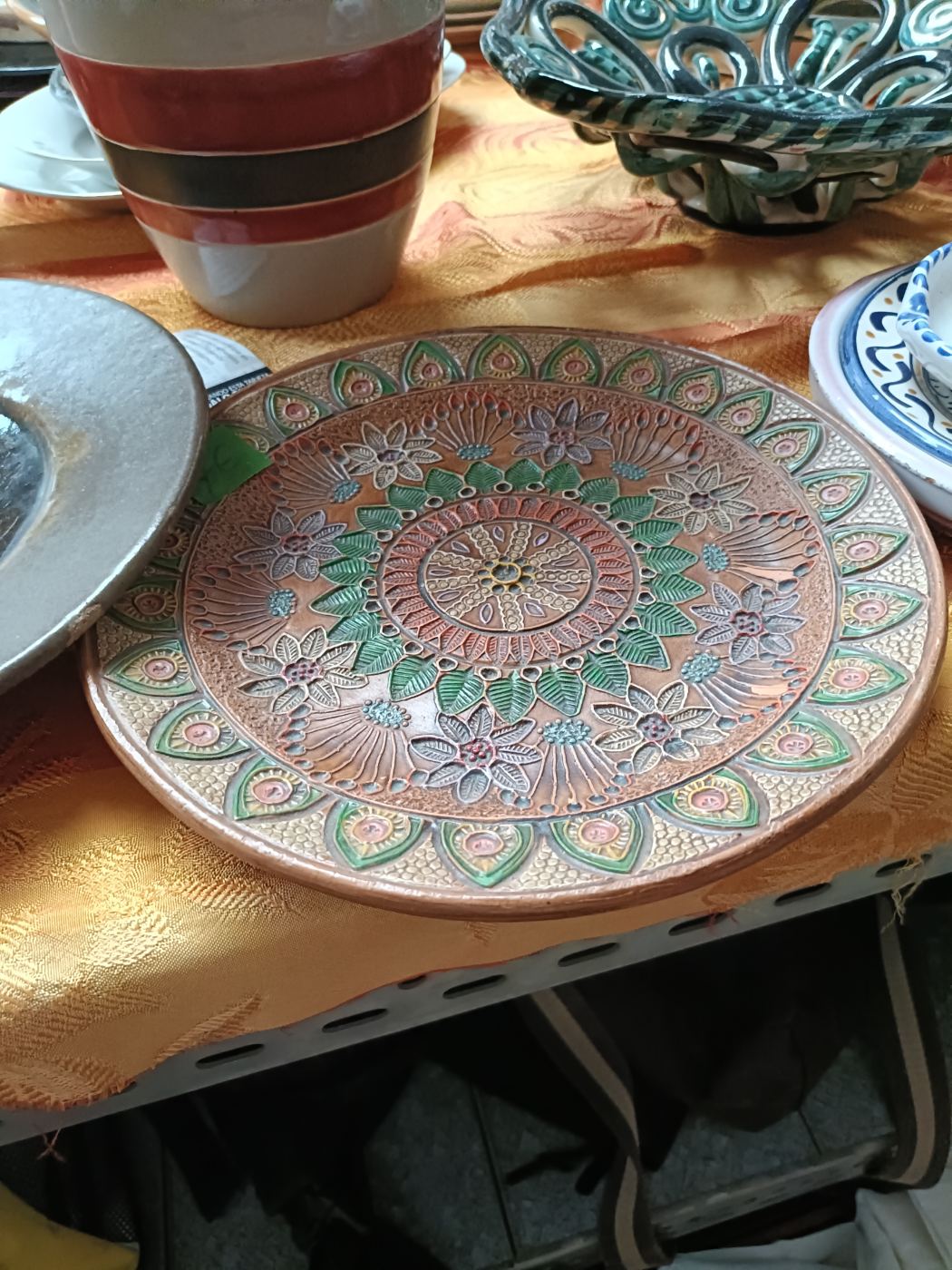 Plato decorativo con relieve floral y tonos verdes y marrones