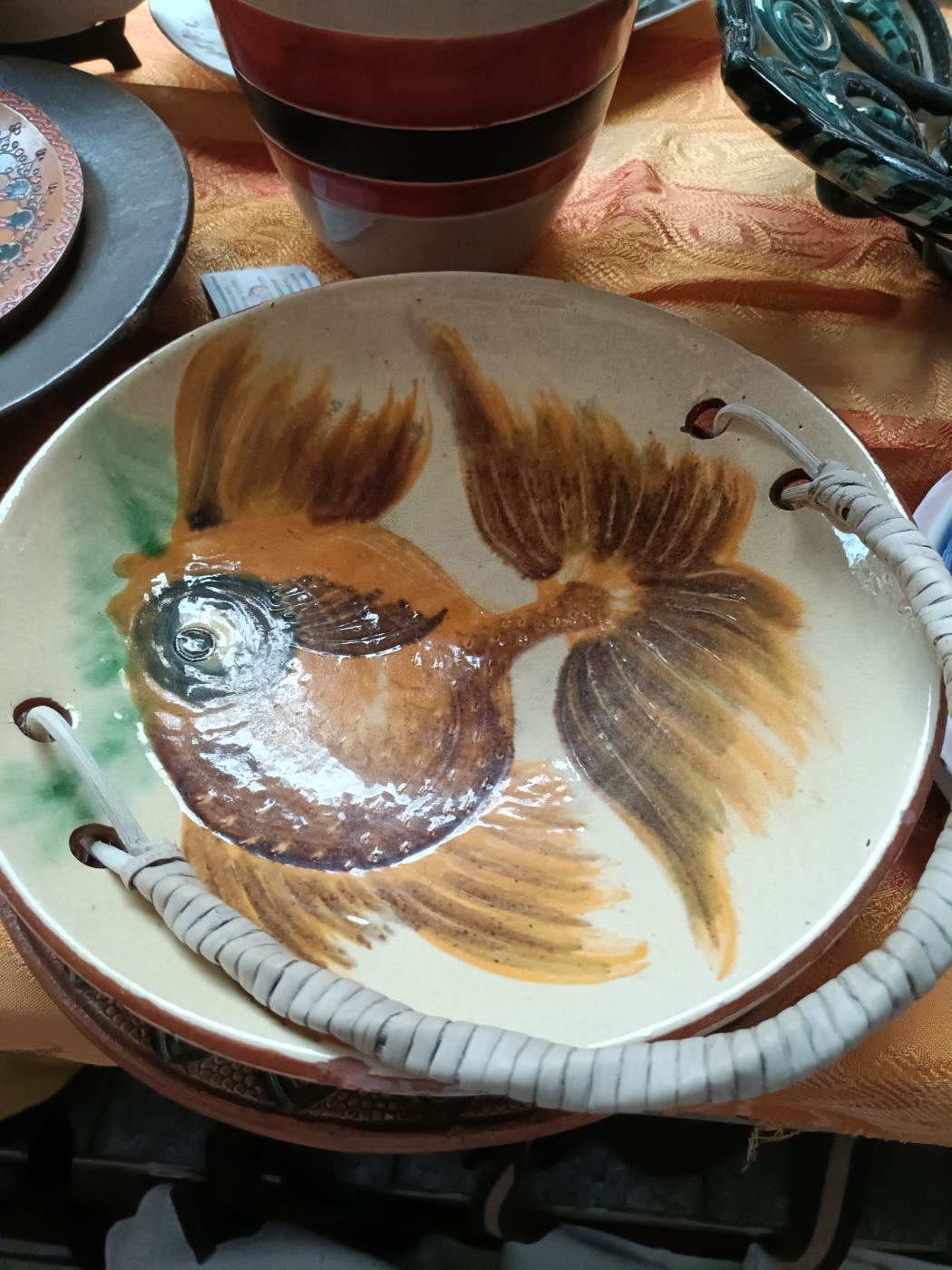 Plato decorativo con dibujo de pez y asas de mimbre